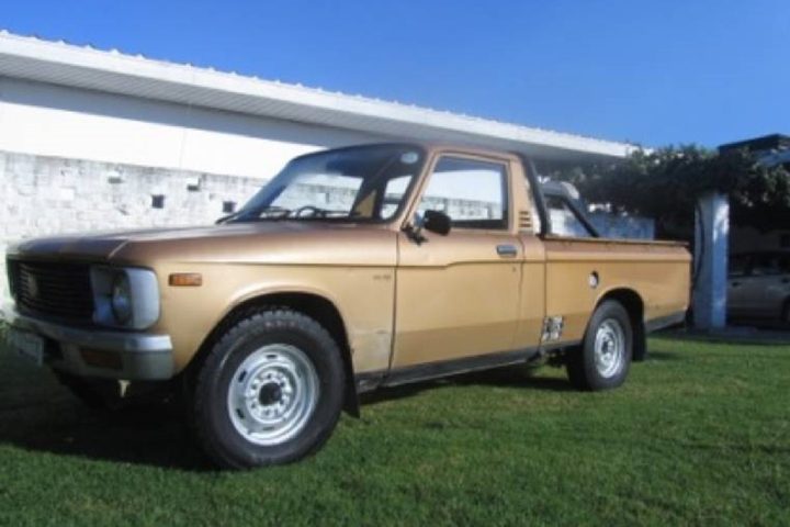A South African half-ton bakkie parked on grass, the kind of light commercial vehicle that needs its own glass